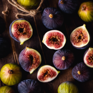 An image showcasing the art of preserving figs: capture the vibrant hues of ripe figs being delicately placed into glass jars, sealed with care, and arranged neatly on wooden shelves, evoking a sense of tradition and the promise of year-round fig flavor